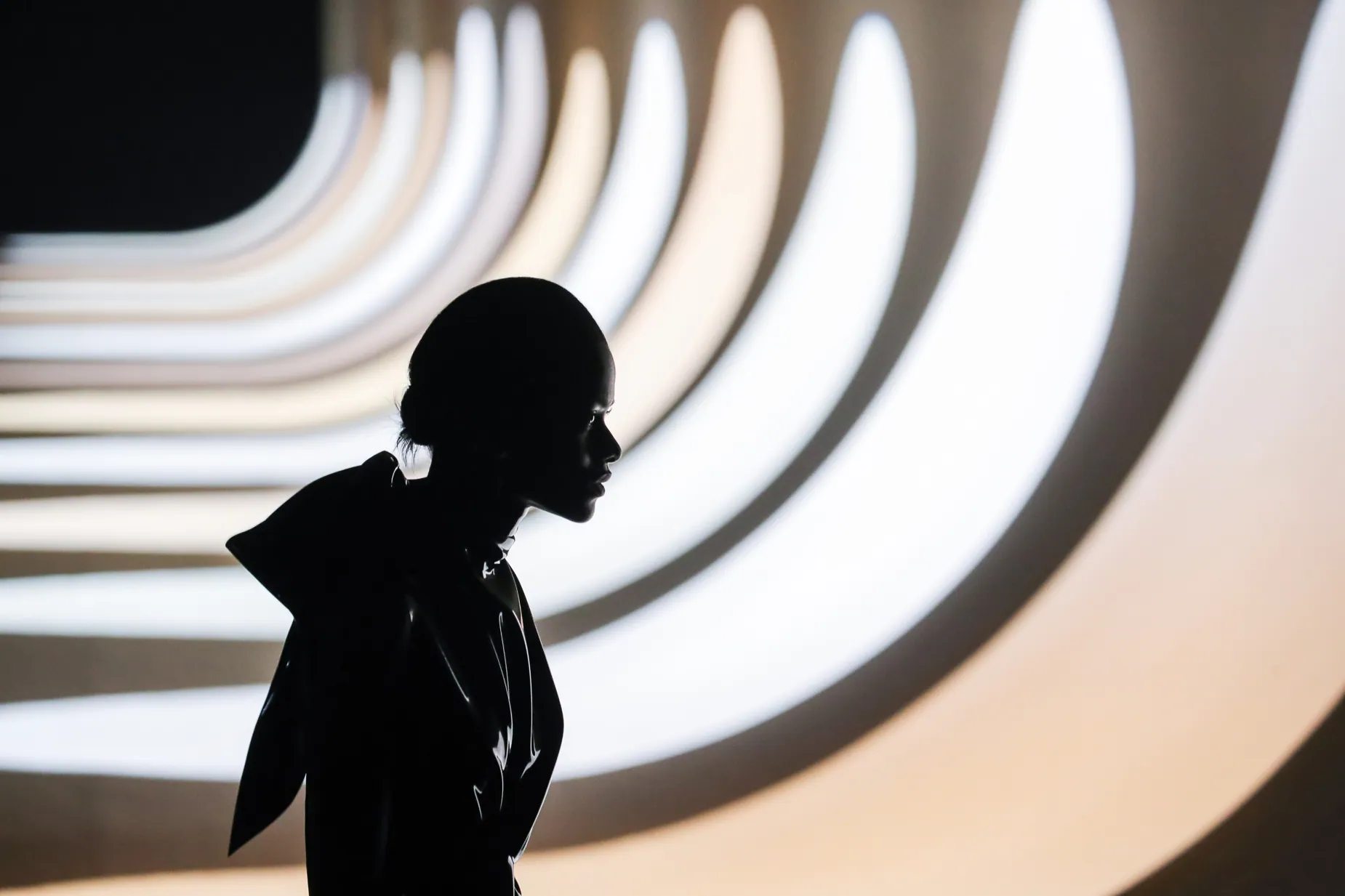 Dark silhouette against a sculptural illuminated Saint Laurent set